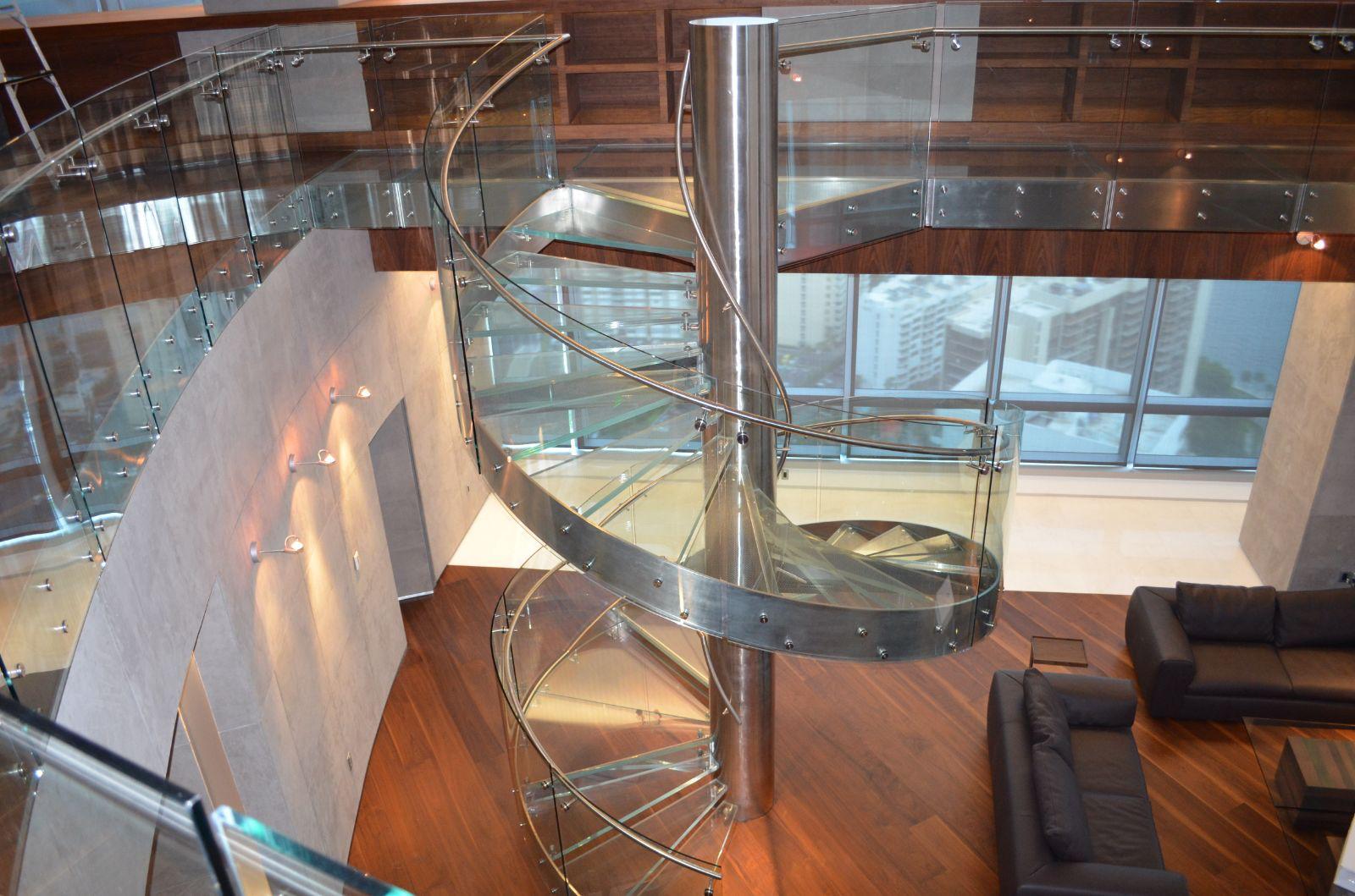 Custom glass and steel spiral staircase in modern penthouse